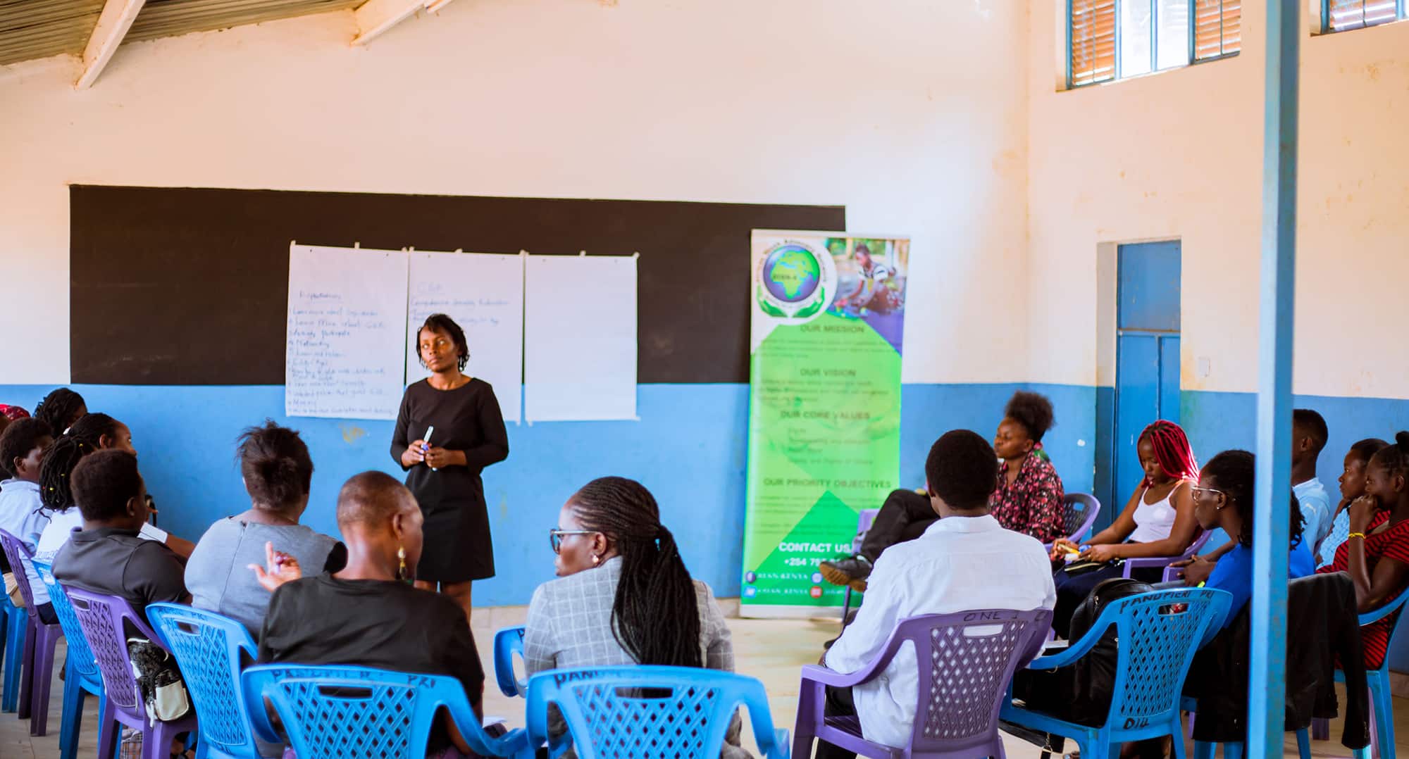 Mwanamke Mwafrika akihutubia darasa la wanafunzi wakubwa