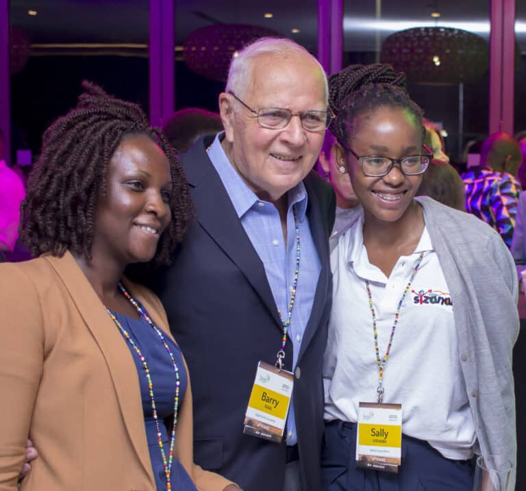 Barry Segal pose avec deux femmes africaines