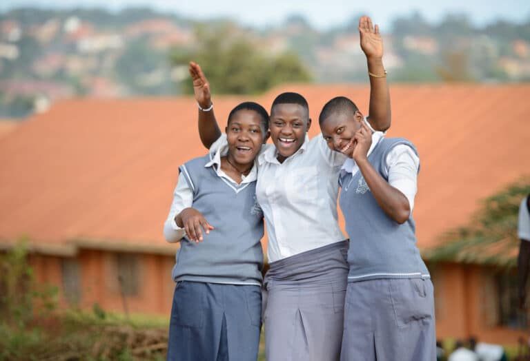 Three schoolgirls smile at the camera