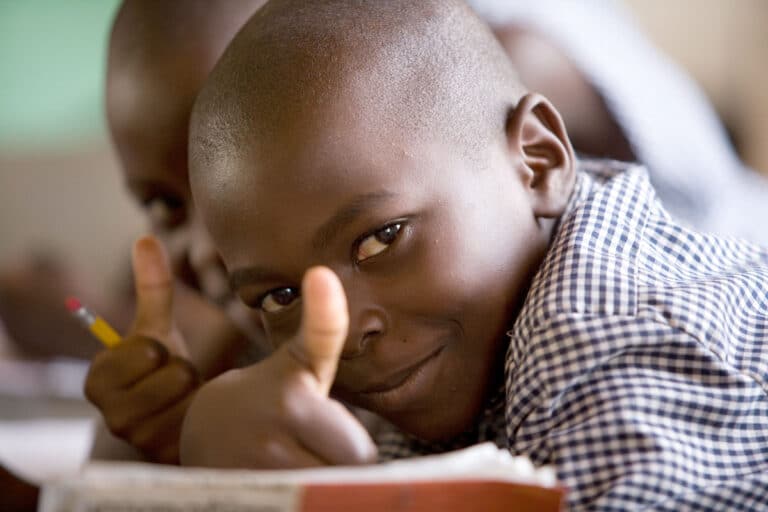 A student gives the thumbs up sign to the camera