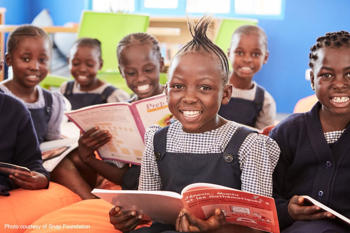 Wasichana wa shule za Kongo wakitabasamu kwenye madawati yao