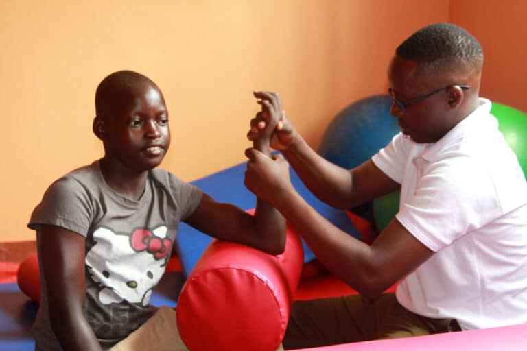 A therapist works with a boy with disabilities