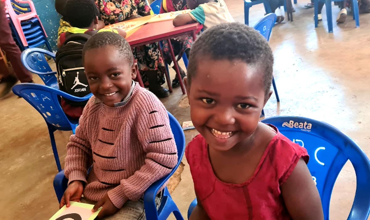 Deux enfants sourient à l'appareil photo