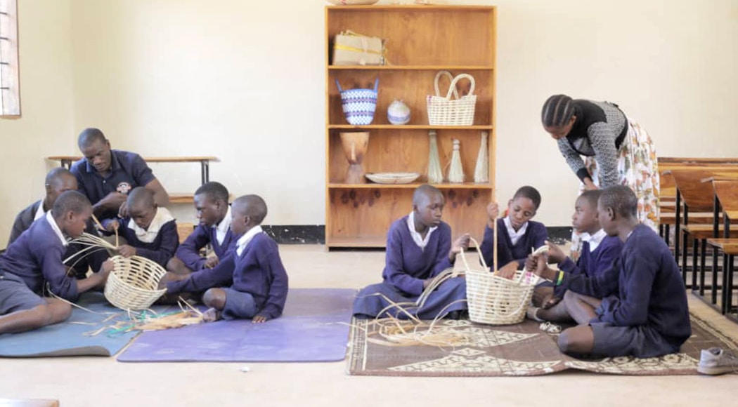 Une classe d'élèves apprend à tresser des paniers