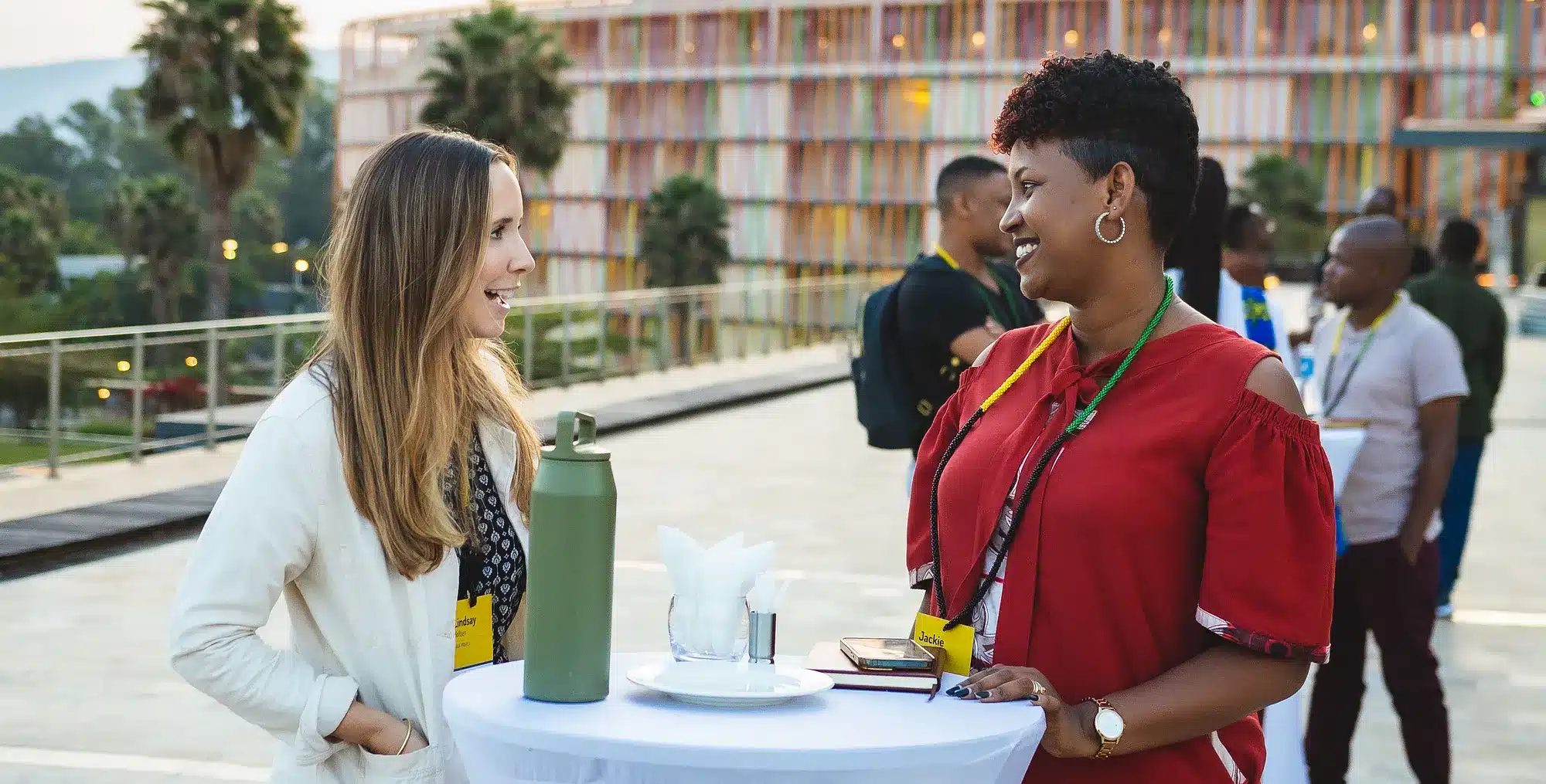 A white woman and a black woman talk to each other on a roofdeck