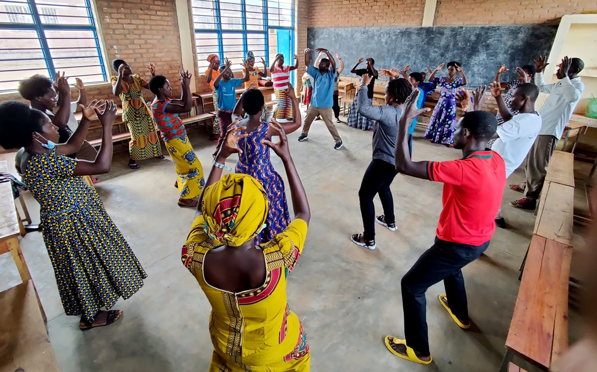 Un groupe de Rwandais participe à un jeu de brise-glace dans une salle de classe.
