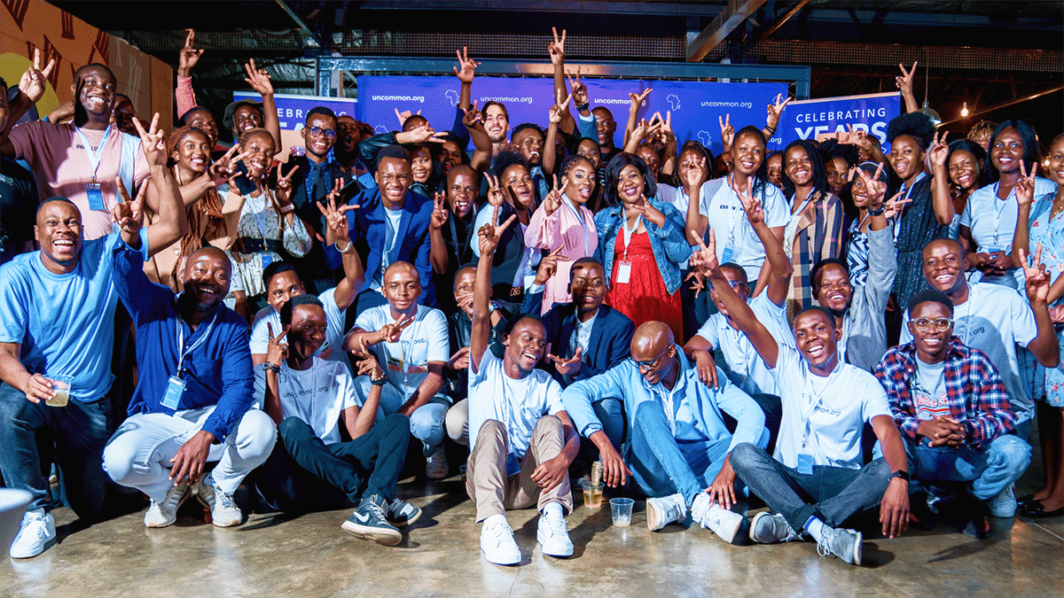 A large group of African adults smile at the camera