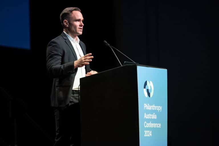 Andy Bryant speaks at a podium in a darkened room