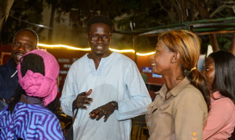 Adults talk at a mixer in Dakar
