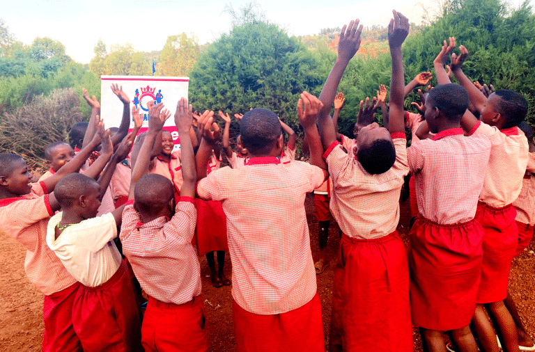 Au Rwanda, un cercle de jeunes filles lèvent les mains en signe de joie.