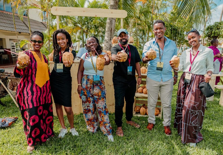 Six adults pose with coconut water