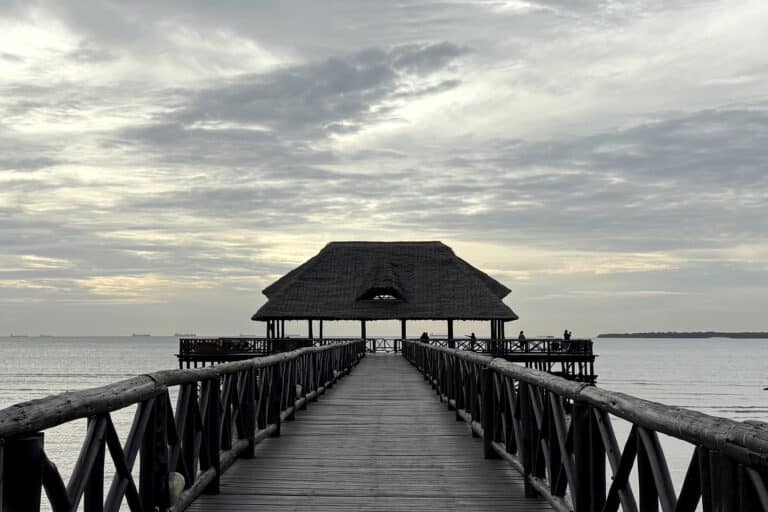 Image of a dramatic sky above a pier stretching into the ocean