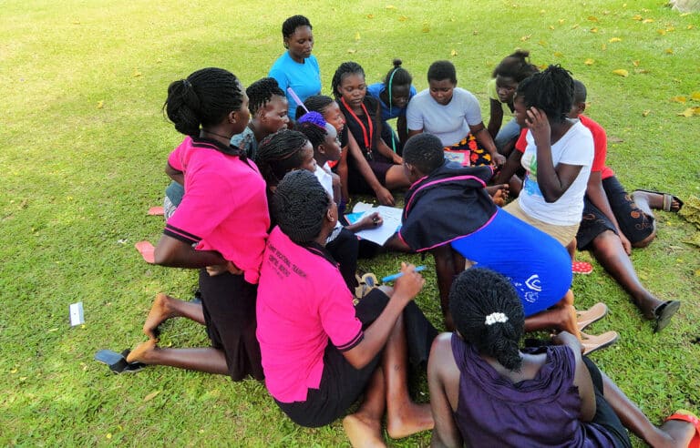 15 young ladies having a discussion on the grass